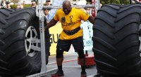 Mark Felix trägt bei einem Strongman-Wettbewerb 2022 zwei Monsterräder auf seinen Schultern