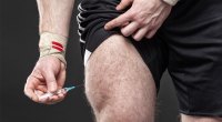 Mann, der seine Quads mit anabolen Steroiden mit einer Spritzennadel injiziert