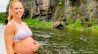 Crossfit-Champion und Mutter Annie Thorisdottir zeigt ihren Babybauch neben einem Fluss