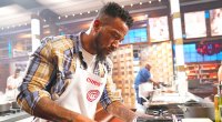 Masterchef-Kandidat Christian Green bereitet sein Cajun-Honig-Knoblauch-Lachs-Rezept zu und trägt die Masterchef-Schürze