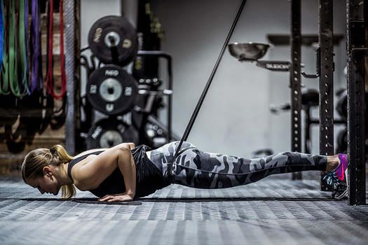 Frau macht gebänderte Liegestütze